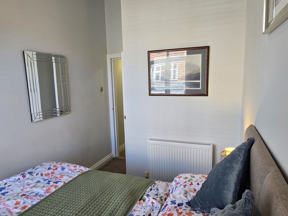 A bedroom with a bed and a door at 2 Fern Avenue Prestatyn