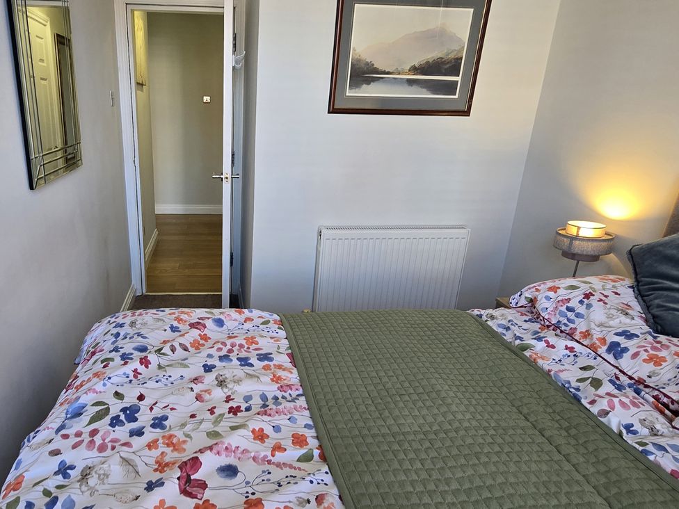 A bedroom with a bed and a door at 2 Fern Avenue Prestatyn