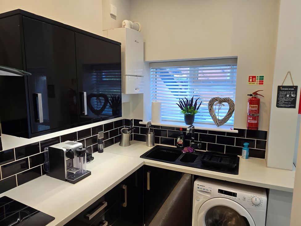 A kitchen with a sink and washing machine at 2 Fern Avenue Prestatyn