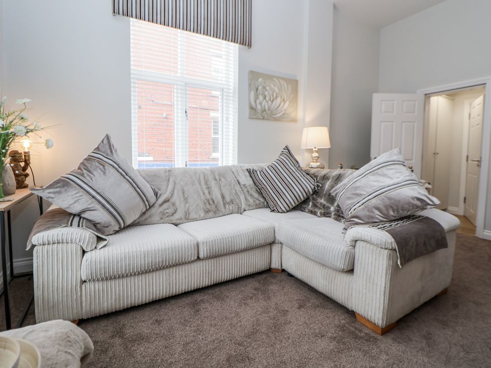 A living room with a sofa and lamp at No 2 Emporium Apartments in Prestatyn