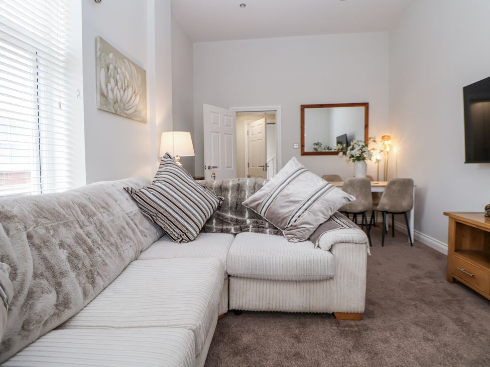 A living room with a sofa and a dining table at No 2 Emporium Apartments Prestatyn