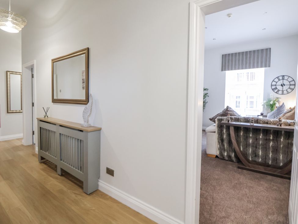 A hallway with a console table and a view of a living room at No 2 Emporium Apartments in Prestatyn