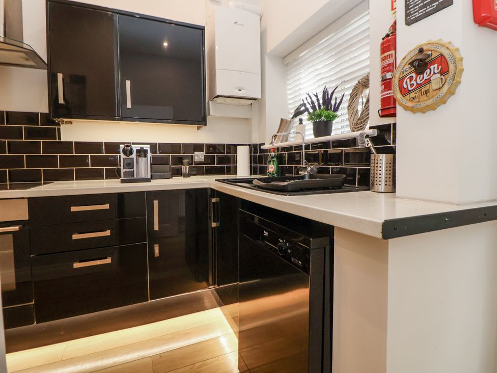 A kitchen with cabinets and appliances at No 2 Emporium Apartments in Prestatyn