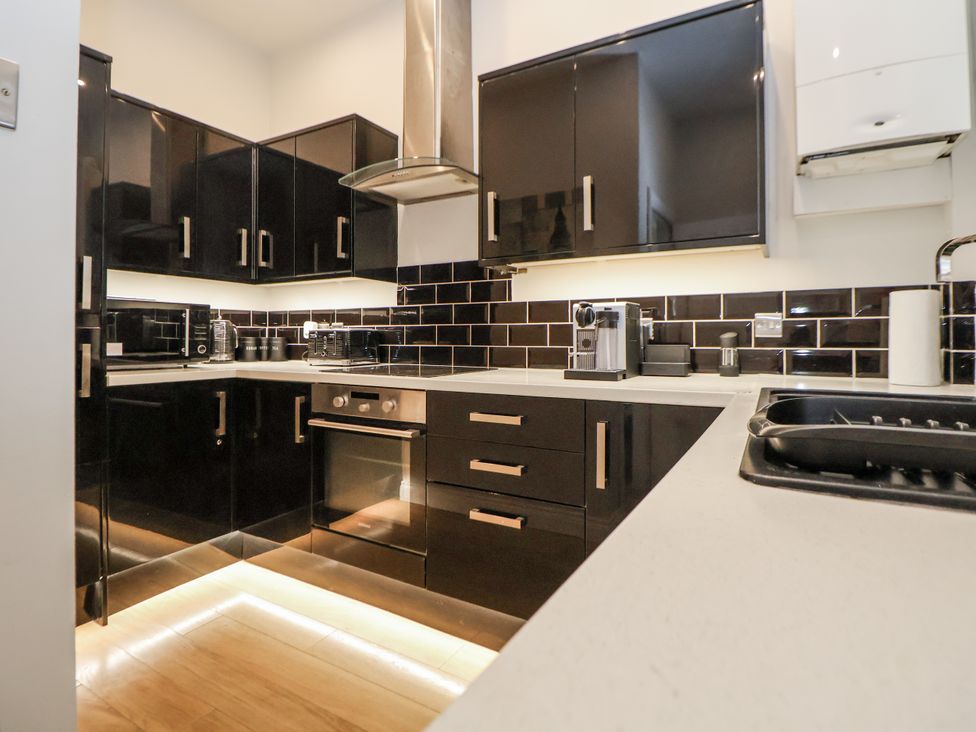 A kitchen with black cabinets and countertops at No 2 Emporium Apartments Prestatyn