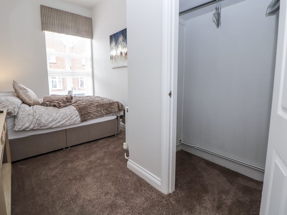A bedroom with a bed and wardrobe at No 2 Emporium Apartments Prestatyn