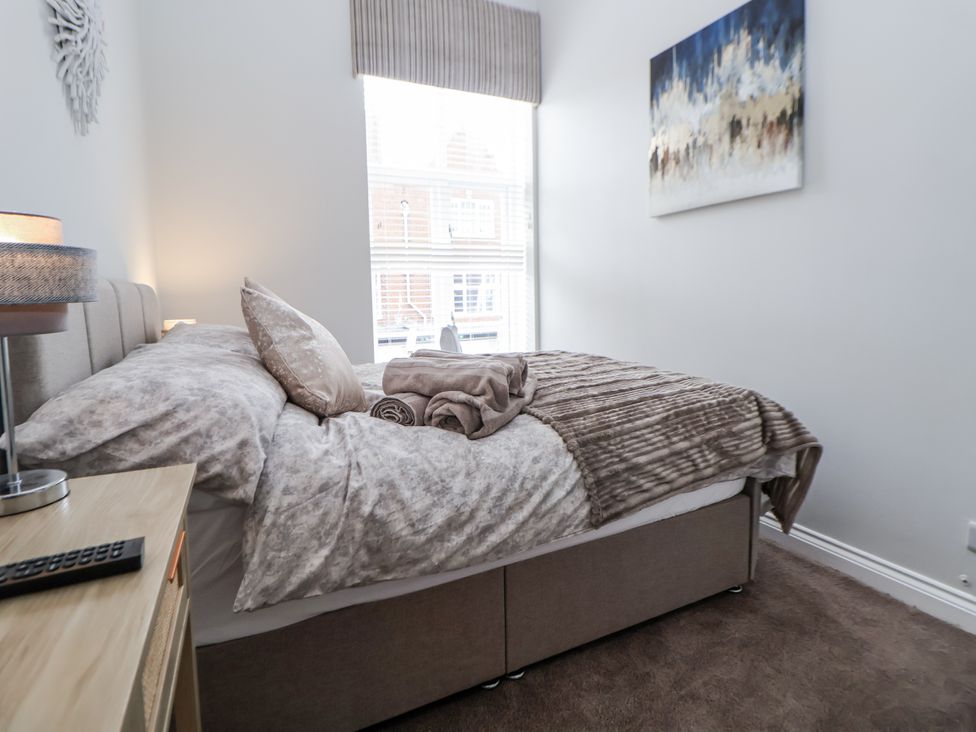 A bedroom with a bed and bedside table at No 2 Emporium Apartments Prestatyn