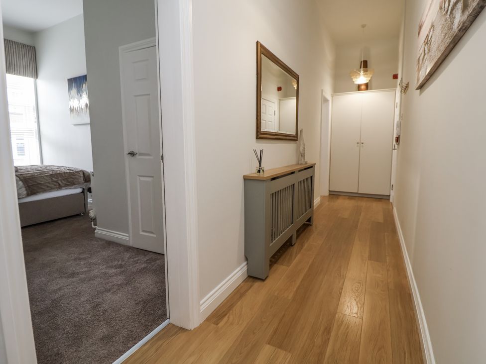 A hallway with a mirror and a storage cabinet at No 2 Emporium Apartments Prestatyn