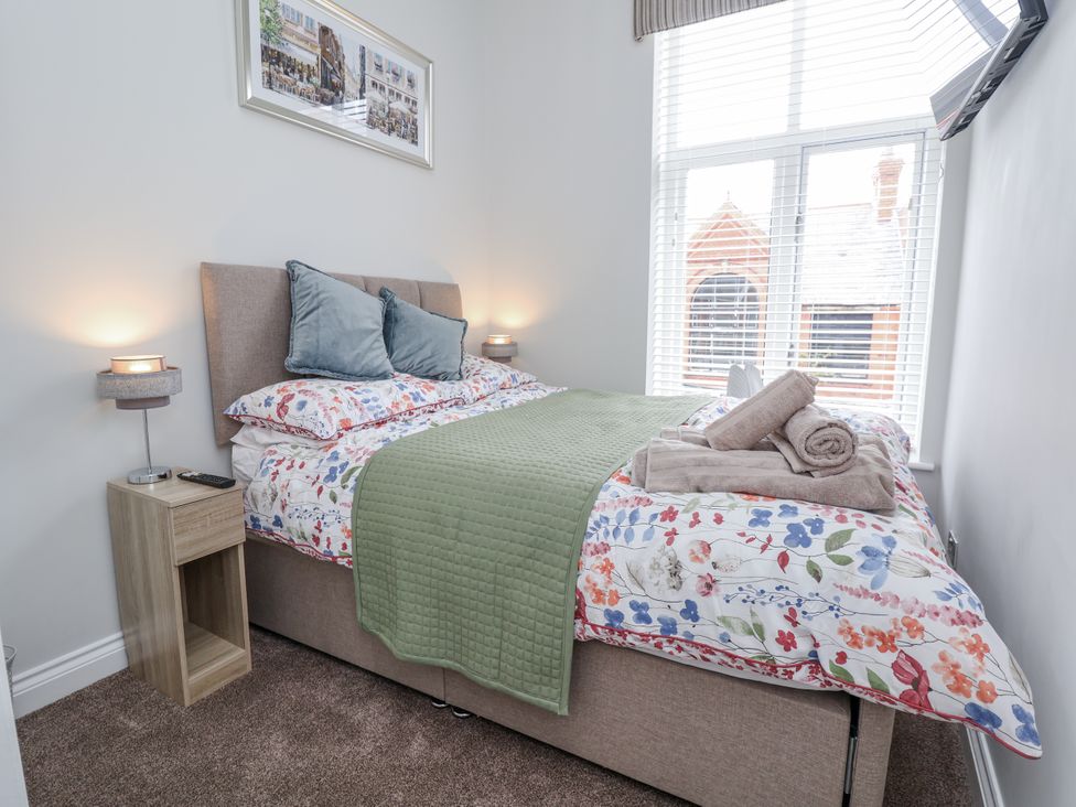 A bedroom with a bed and nightstand at No 2 Emporium Apartments in Prestatyn