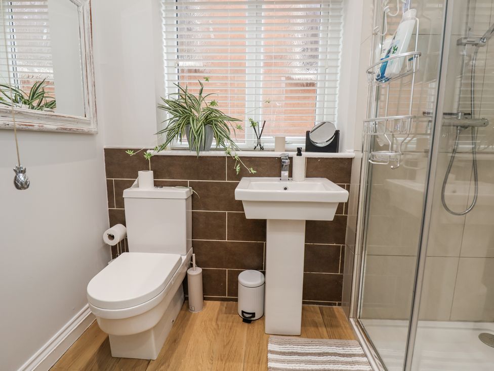 A bathroom with a toilet, sink, and shower at No 2 Emporium Apartments, Prestatyn