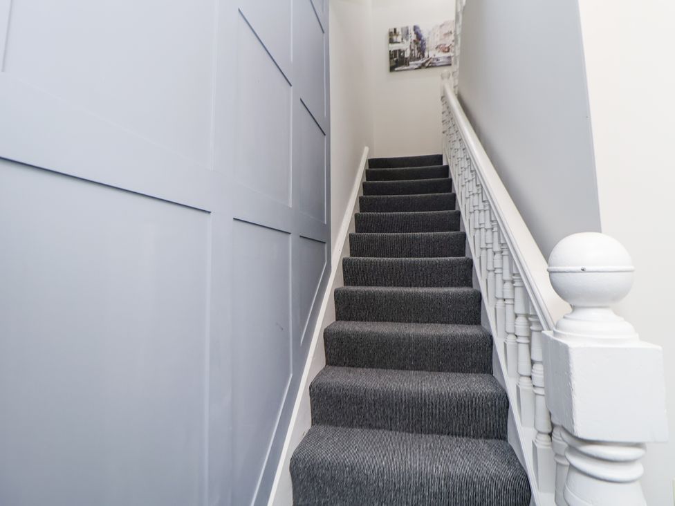 A staircase with grey carpet and a handrail at No 2 Emporium Apartments Prestatyn