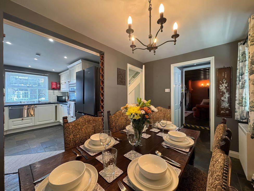 A dining room with a table set for dinner at St. James Cottage in Liskeard
