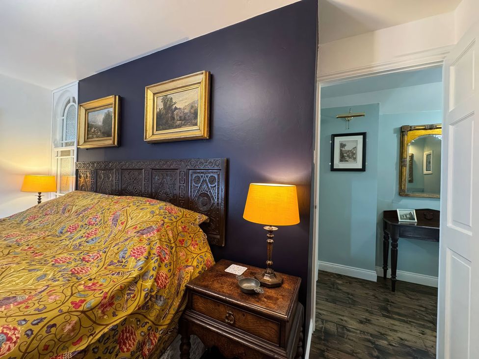 A bedroom with a bed and bedside lamp at St. James Cottage Liskeard