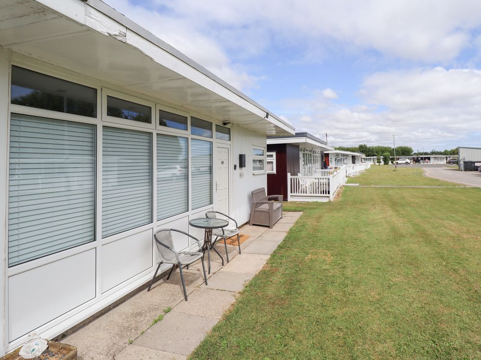 An outdoor area with a table and chairs at 66 Cherry Park in Skegness