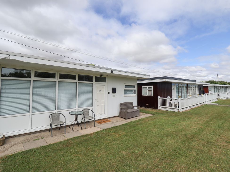 A view of a property with seating area and multiple cabins at 66 Cherry Park in Skegness