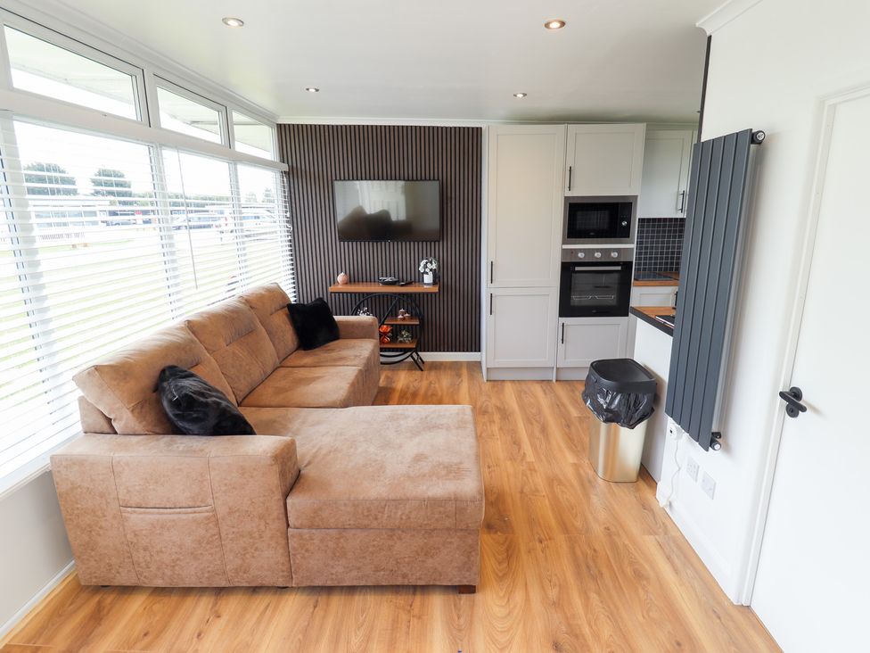 A living room with a sofa and television at 66 Cherry Park in Skegness