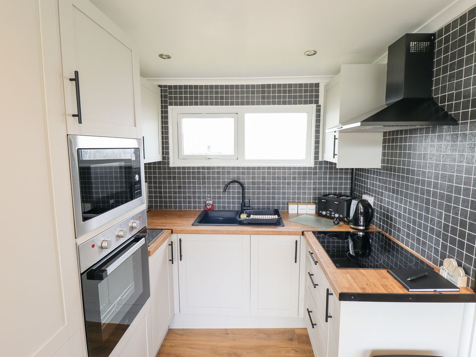 A kitchen with an oven and sink at 66 Cherry Park in Skegness