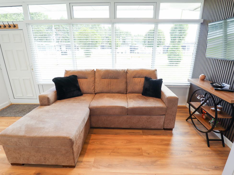 A living room with a sofa and a television at 66 Cherry Park Skegness