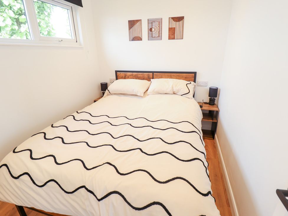 A bedroom with a bed and artwork at 66 Cherry Park in Skegness