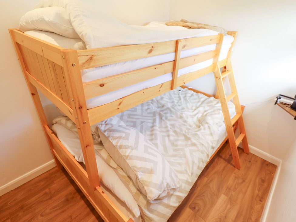 A bunk bed with pillows and mattresses at 66 Cherry Park in Skegness