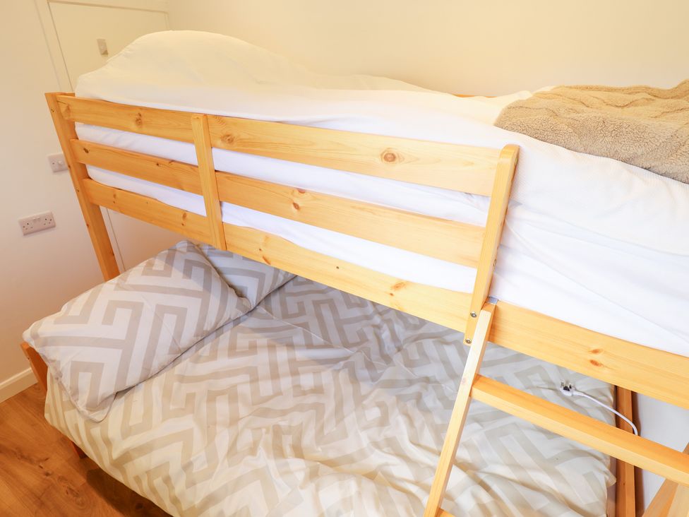 A bunk bed with a mattress and pillow at 66 Cherry Park Skegness