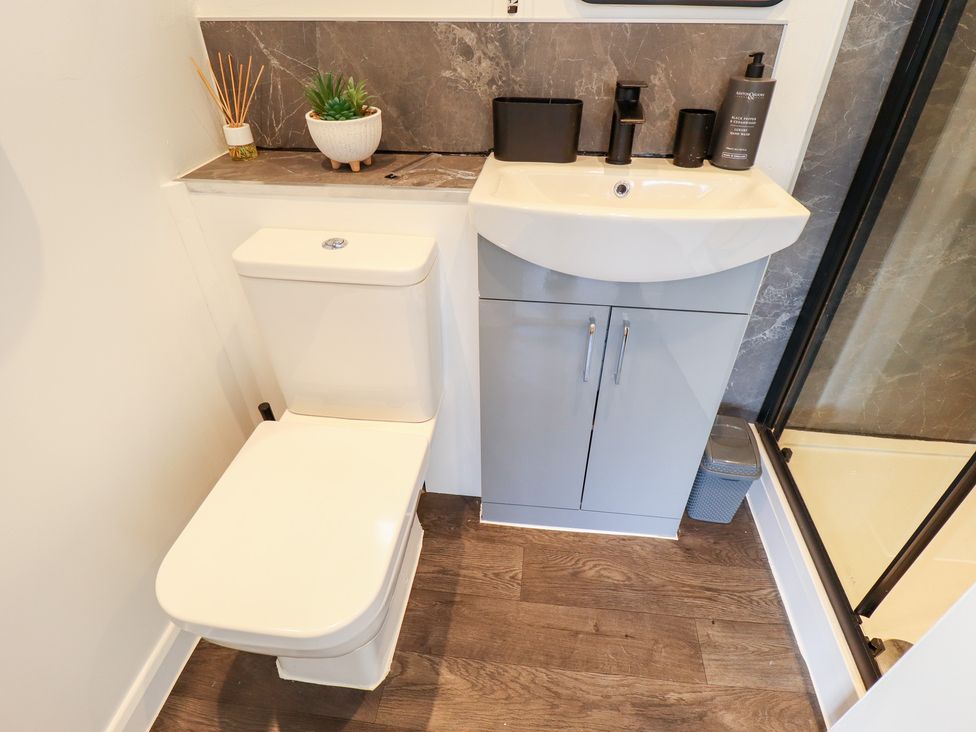 A bathroom featuring a toilet, sink, and shower at 66 Cherry Park in Skegness 