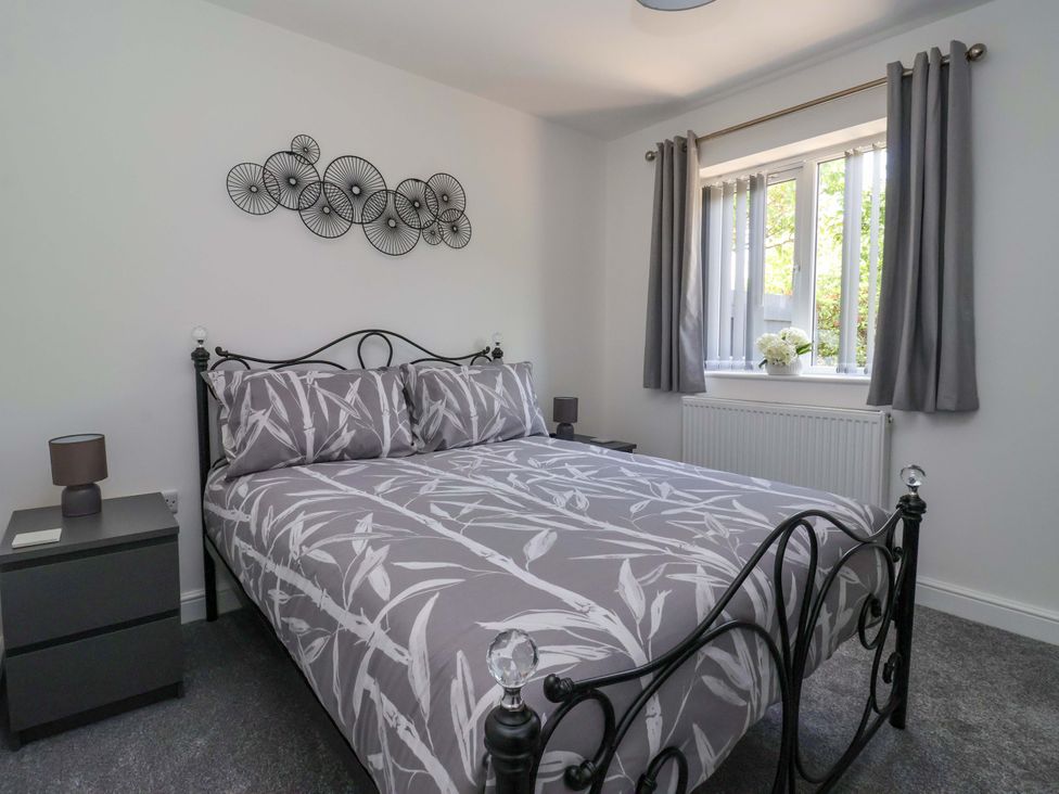 A bedroom with a bed and bedside table at Dan’s Holiday Cottage in Driffield
