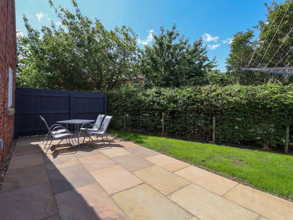 A garden with a table and chairs at Dan’s Holiday Cottage in Driffield