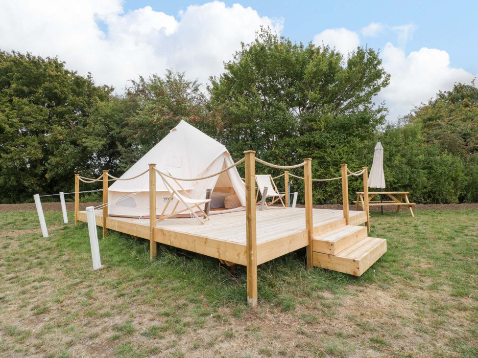 A glamping tent on a wooden deck with steps at Bell 2 near Shades Farm