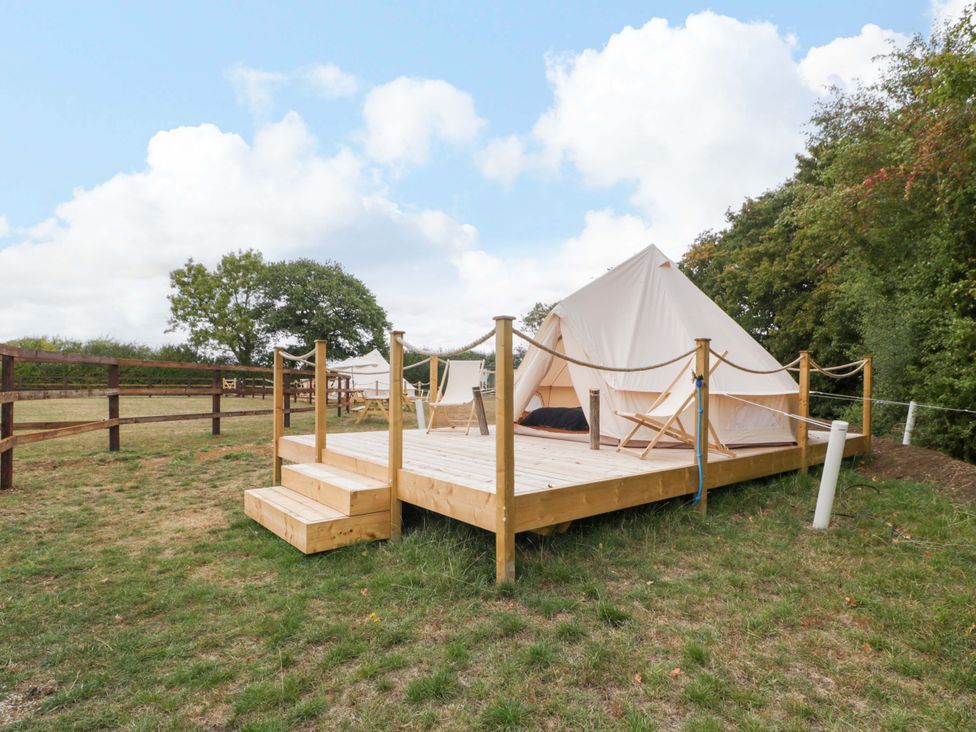 A tent on a wooden deck at Bell 2 Shades Farm near Malmesbury