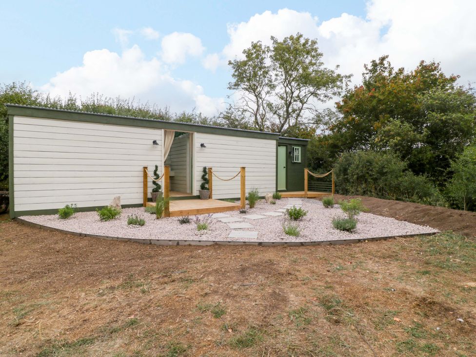 A building with a wooden walkway and plants at Bell 2, Shades Farm near Malmesbury