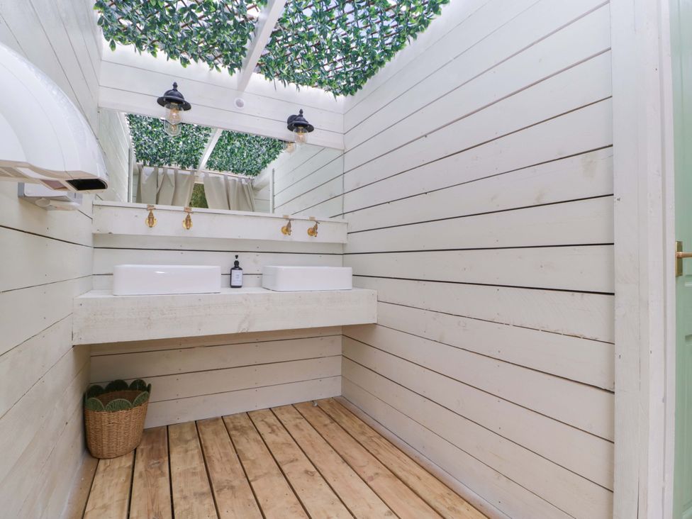 A bathroom with sinks and a hand dryer at Bell 2, Shades Farm near Malmesbury