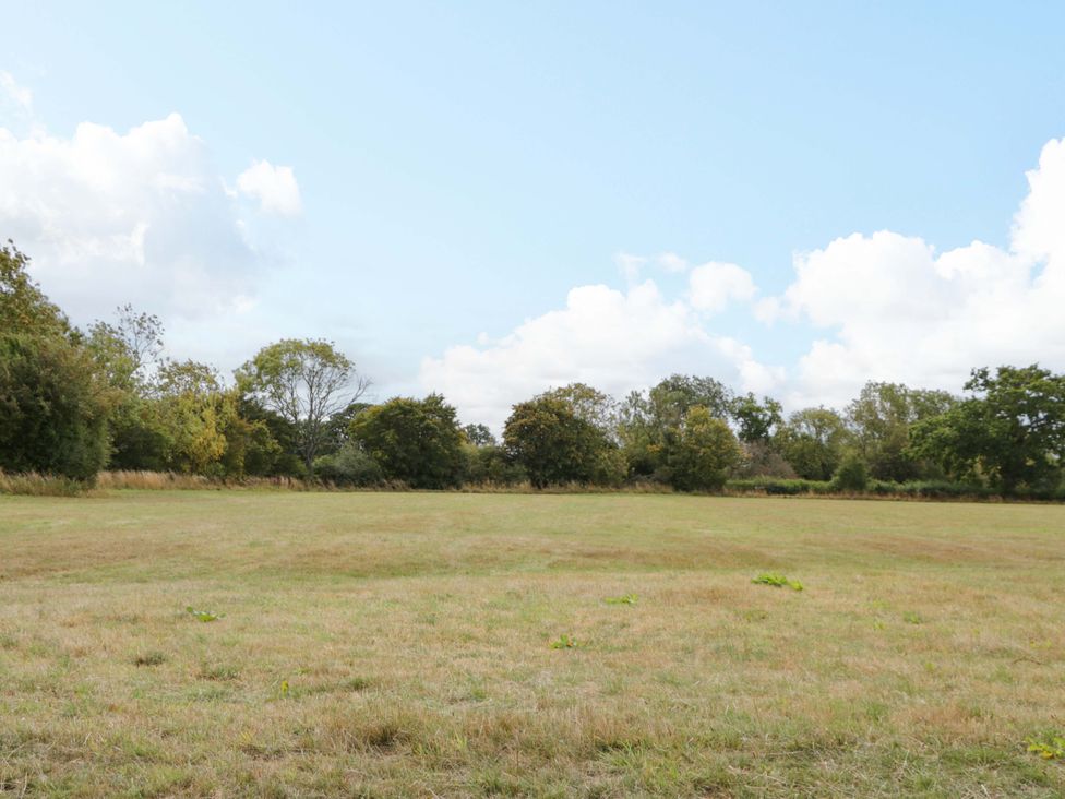A field with trees and clouds at Bell 2 in Shades Farm near Malmesbury