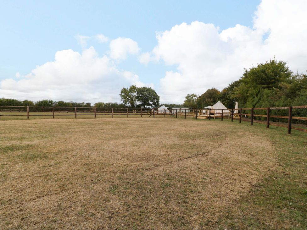 An outdoor area with a fenced space and tents at Bell 2 near Malmesbury