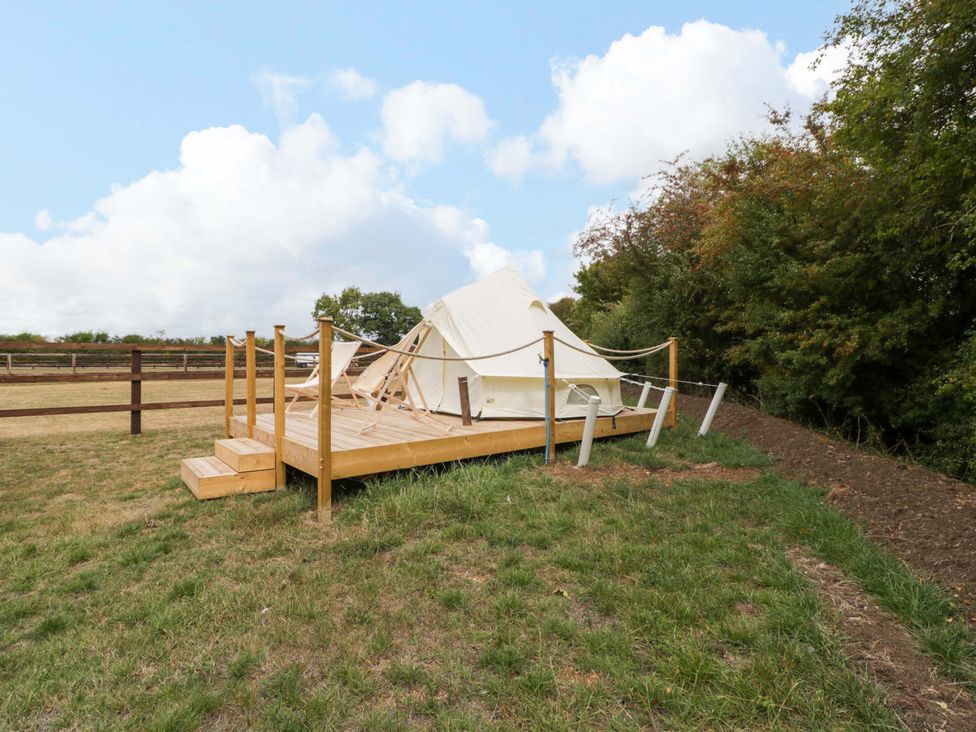 A tent on a wooden deck in an outdoor space at Bell 3 Shades Farm near Malmesbury