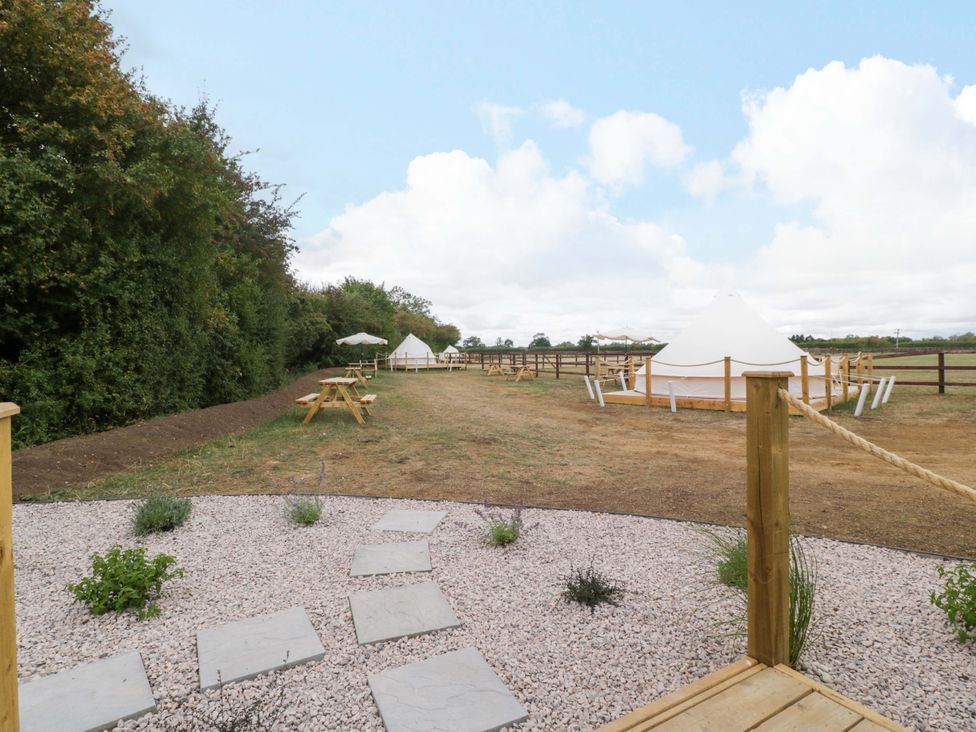 An outdoor space with tents and benches at Bell 3 Shades Farm near Malmesbury