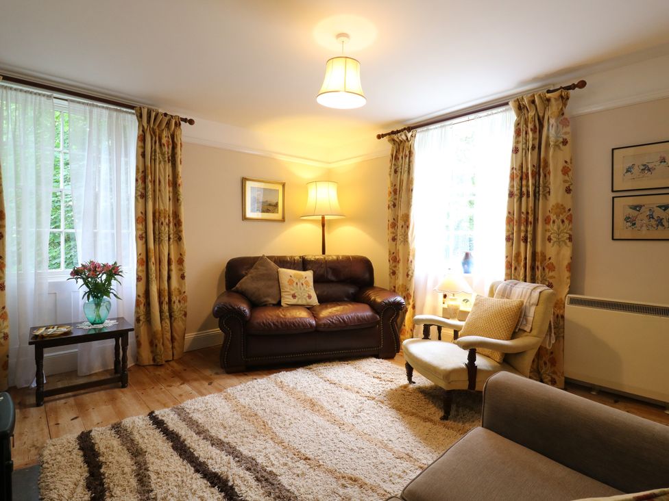A living room with a sofa and floor lamp at Curry Farm