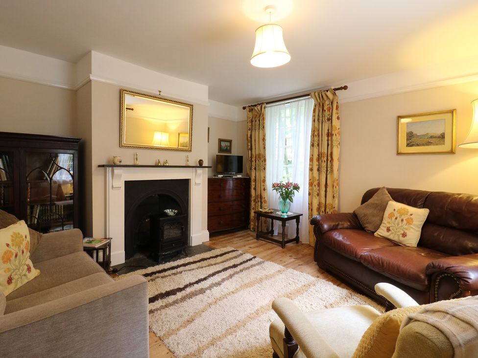 A living room with a fireplace and sofa at Curry Farm