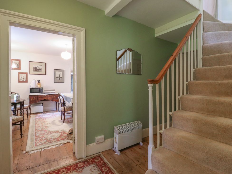 A hallway with staircase and access to a dining area at Curry Farm