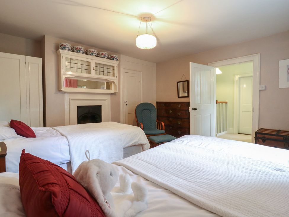 A bedroom with two beds and a chair at Curry Farm