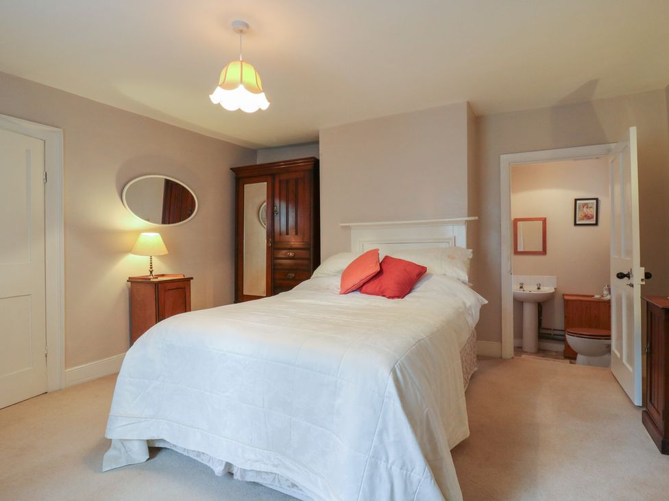 A bedroom with a bed, wardrobe, and an adjoining bathroom at Curry Farm