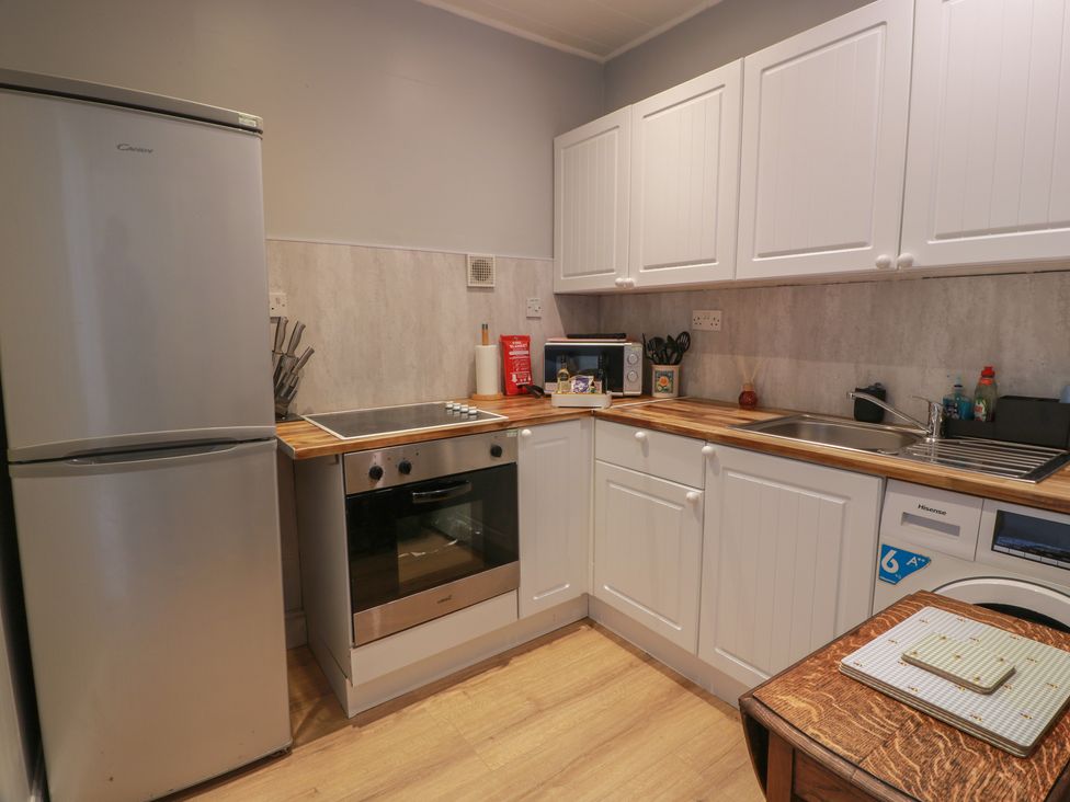 A kitchen with a refrigerator, oven, sink, and microwave at 6 George Street Isle of Cumbrae