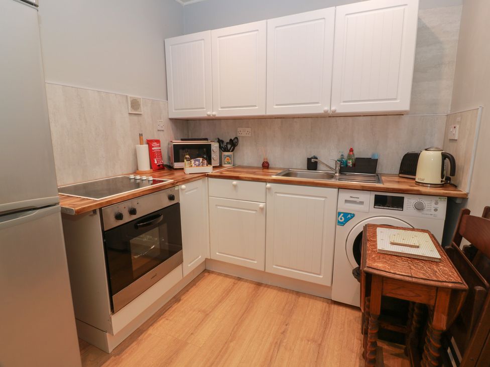 A kitchen with appliances and a table at 6 George Street Isle of Cumbrae