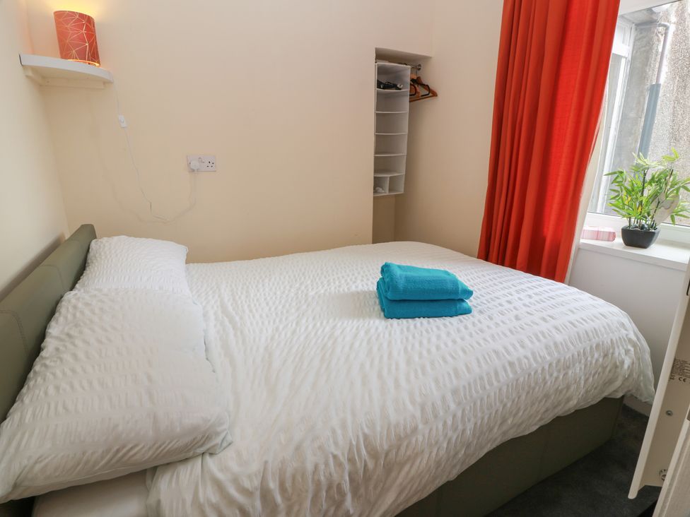 A bedroom with a bed and towels at 6 George Street in Isle of Cumbrae