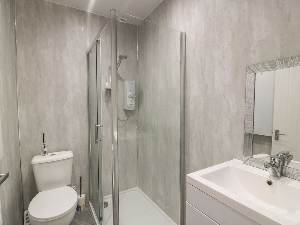 A bathroom with a shower, toilet, and sink at 6 George Street Isle of Cumbrae