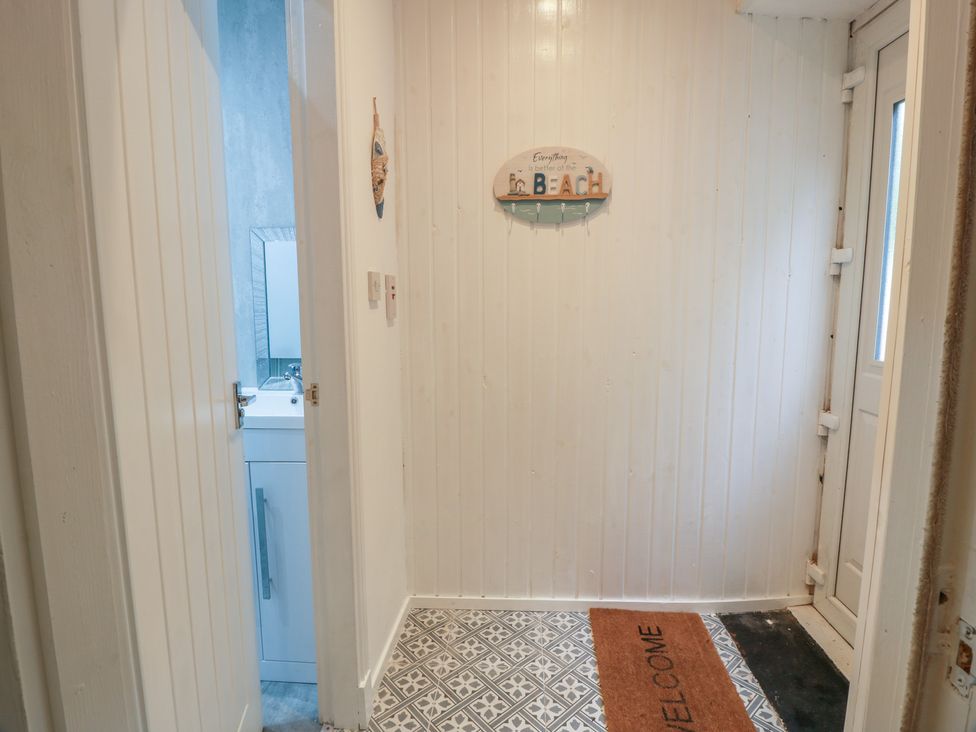 A hallway with a door and a mirror at 6 George Street Isle of Cumbrae