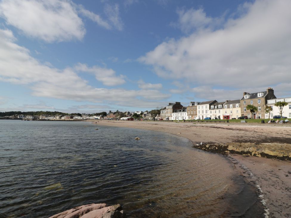 A beach with water and buildings nearby at 6 George Street Isle of Cumbrae
