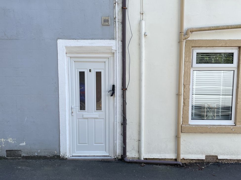 An entrance door and a window with pipes at 6 George Street in Millport