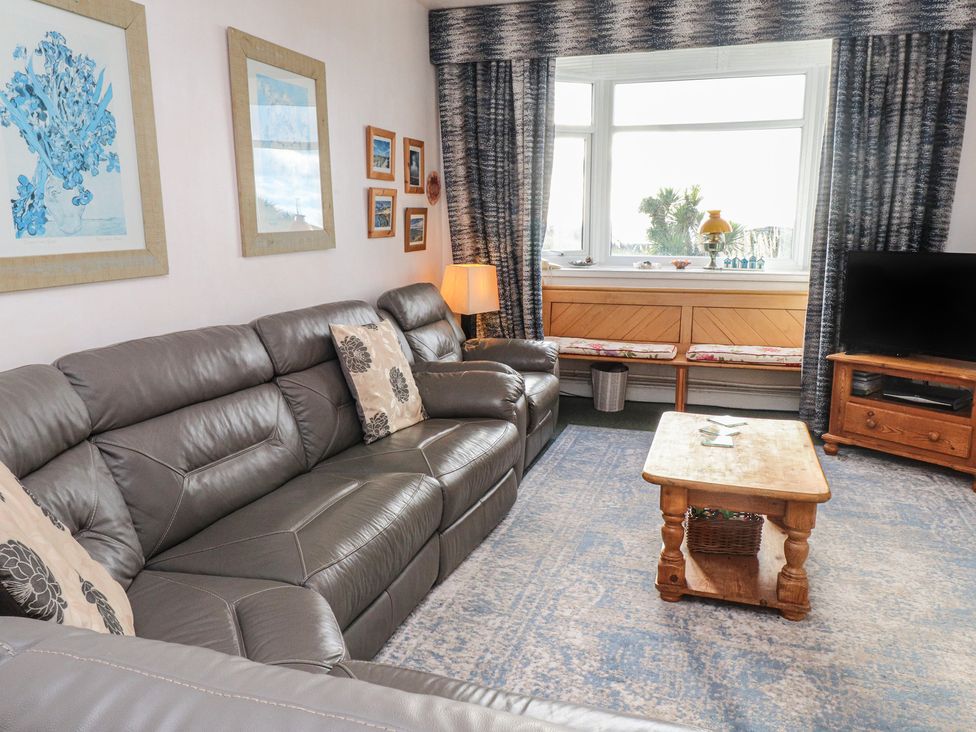 A living room with a sofa and a coffee table at King Arthur Suite in Trearddur Bay