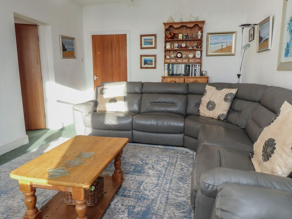A living room with a sofa and coffee table at King Arthur Suite in Trearddur Bay
