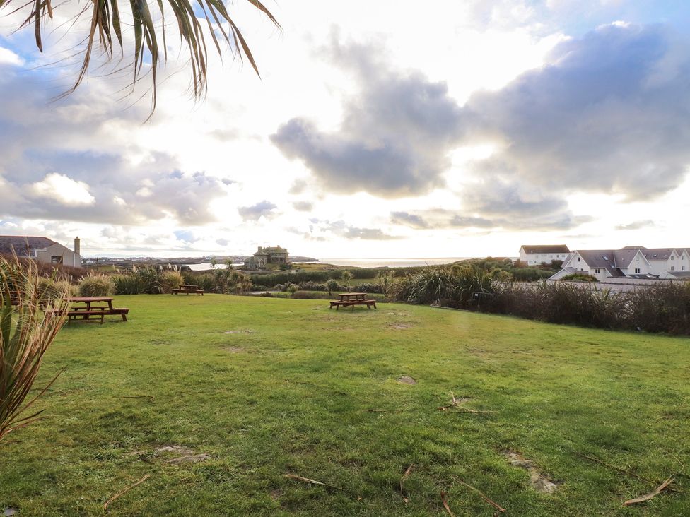 An outdoor area with picnic tables and ocean view at King Arthur Suite in Trearddur Bay